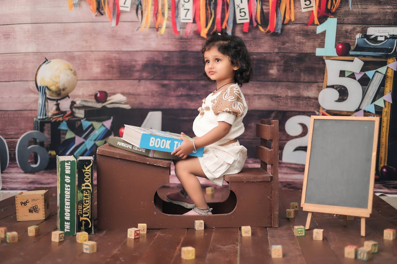 Adorable child in a classroom setting with books and educational props, creating a playful learning atmosphere.